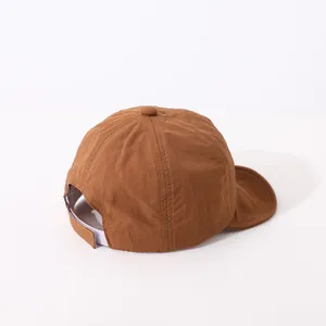 Detailed view of brown cotton baseball cap with adjustable Velcro strap on a white background