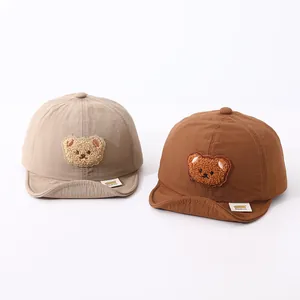 Detail of baby soft-brim baseball caps with cute plush bear patches and breathable fabric