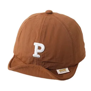 Caramel brown soft brim kids baseball cap with white embroidered letter P in functional fabric