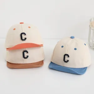 Dettaglio del ricamo lettera C su cappellini da baseball morbidi in cotone per neonati