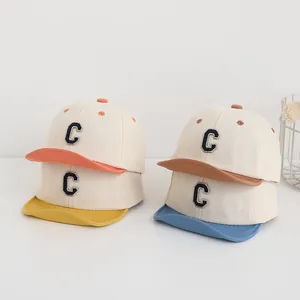 Dettaglio di cappellini da baseball per neonati in cotone con ricamo C in quattro colori