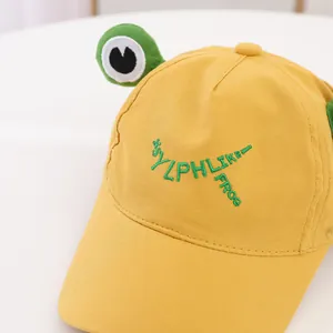 Detail der gelben Baseballkappe mit grünen 3D-Froschaugen und SYLPH LIKE FROG Stickerei