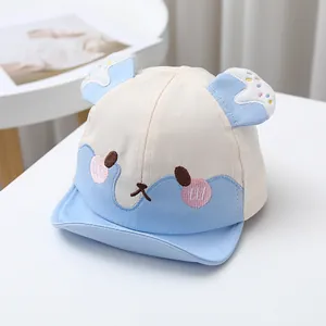 Detail der Baby-Baseballkappe mit blauer Bärenstickerei und 3D-Ohren auf weißem Tisch