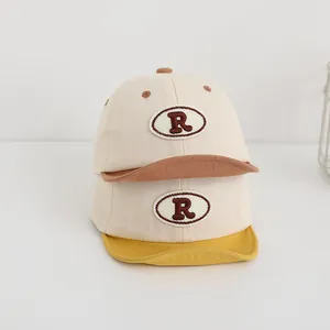 Ricamo dettagliato della lettera R su cappellini da baseball in cotone beige per neonati