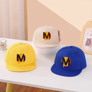 Dettaglio cappellino piatto per bambini con ricamo a lettera M in 3D e tessuto di cotone