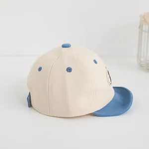 Dettaglio del berretto da baseball in cotone per bambini con visiera blu e toppa ricamata