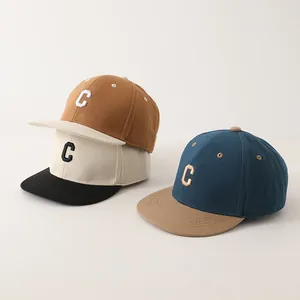 Detailweergave van canvas baseballpetten met kleurblokken en hoogwaardig C-borduurwerk