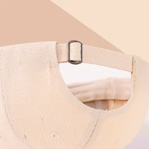 Dettaglio della fibbia in metallo regolabile e del tessuto beige del cappellino per bambini