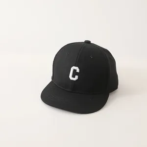 Detailweergave van de witte geborduurde letter C op een zwarte hiphop pet van katoen