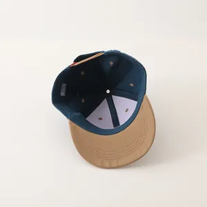 Detail van de versterkte binnenstructuur en stiksels op een tweekleurige baseballpet voor kids