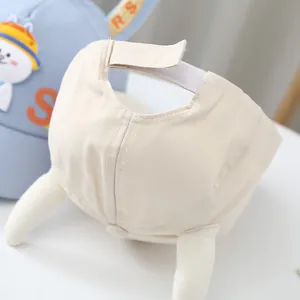 Détail d'une casquette bébé en coton avec fermeture velcro réglable et coutures de précision