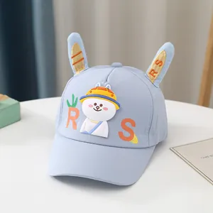 Détail de casquette enfant bleu clair avec oreilles de lapin et broderie cartoon