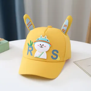 Détail de la casquette jaune pour enfants avec oreilles de lapin et lettres RS brodées