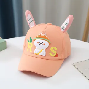 Détail de casquette enfant orange-rose avec oreilles de lapin 3D et broderie RS
