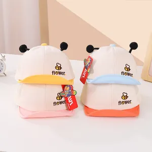 Detalle de gorras de béisbol para bebé con malla transpirable y pompones suaves