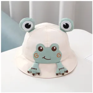 Détail d'un chapeau bob beige pour bébé avec design grenouille 3D et broderie fine