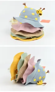 Detail view of cotton baby sun hats in five pastel colors with 3D giraffe decorations