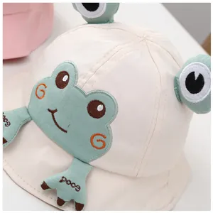 Détail du chapeau bob pour bébé avec broderie de grenouille et yeux en peluche