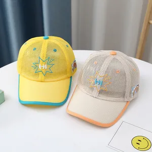 Detalle de gorras de malla para niños con bordado HI y parches de dinosaurios