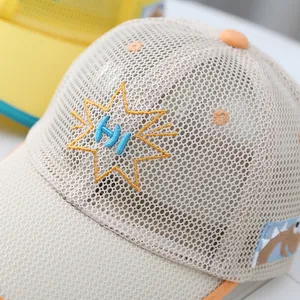 Detalle de gorra de malla para niños con bordado HI y parche de dinosaurio suave