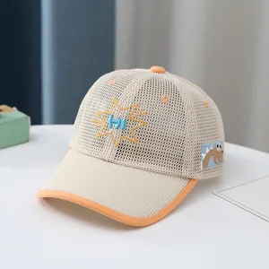 Detalle de tela de malla transpirable con bordado HI y parche de dinosaurio en gorra infantil