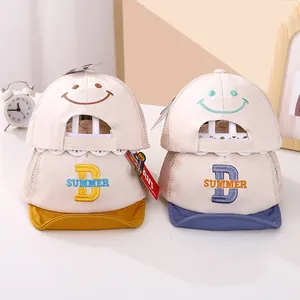 Detail of two mesh baby baseball hats with embroidered smiley faces and breathable mesh