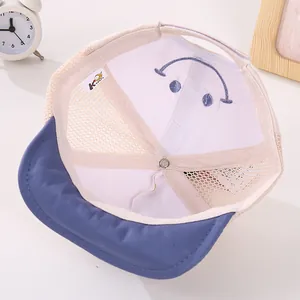 Close-up of the breathable mesh texture and embroidered smiley face on the kid's baseball cap