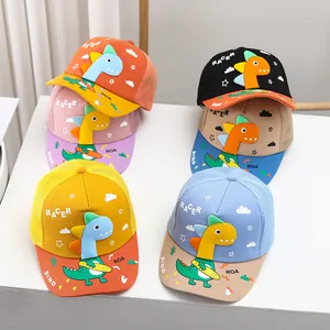 Detalle de gorras infantiles con dinosaurios 3D y lemas de carreras en varios colores