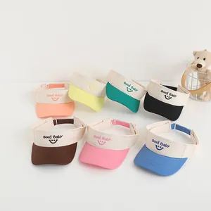 Detail of colorful smiley face embroidery on children's open top sun visor hats