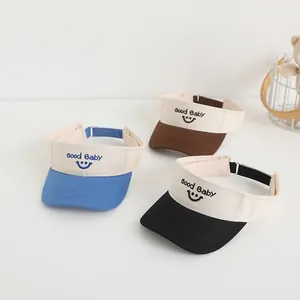 Three children's open-top sun hats with Good Baby smile embroidery in blue, brown and black