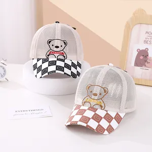Close-up of baby mesh trucker hats with bear embroidery and checkered pattern visors