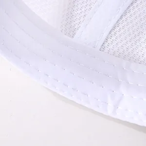 Détail du tissu en maille respirante blanche et des coutures précises sur la casquette bébé