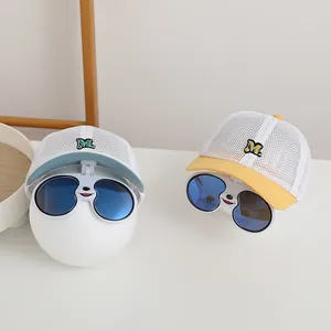 Detail of breathable kids mesh cap featuring foldable cartoon sunglasses and M embroidery