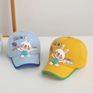 Détail de la broderie lapin sur les casquettes de baseball pour enfants bleues et jaunes