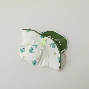 Detail of baby sun hat featuring green frog print and integrated protective neck flap
