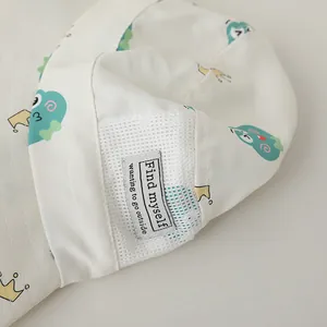 Detail of baby sun hat featuring breathable white mesh and a decorative woven text label