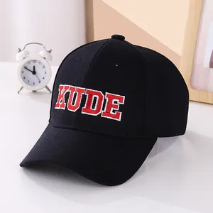 Close-up of red KUDE 3D embroidery on black cotton fabric of a baseball cap detail