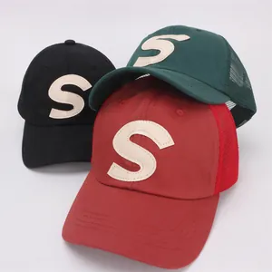 Detail of breathable mesh backing and letter S embroidery on colorful baseball caps