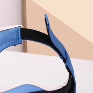 Detail of adjustable black hook-and-loop strap on a blue and beige ponytail sun hat
