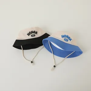 Detail of mesh top kids bucket hats with HONGK 1997 embroidery and adjustable chin strap