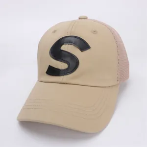 Detail of khaki kids trucker hat with black leather S patch and breathable mesh back