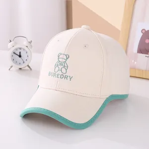 Detailed embroidery of a cute green bear and text on a beige cotton children's baseball cap