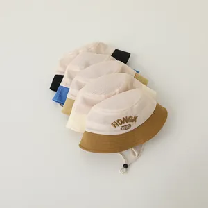 Detail of mesh sun hats for kids with HONGK 1997 embroidery and adjustable chin straps