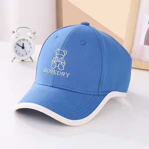 Detailed bear embroidery and BUREDRY lettering on blue cotton baseball cap for kids
