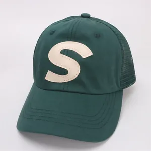 Detail of dark green mesh baseball cap with ivory S letter patch and reinforced stitching
