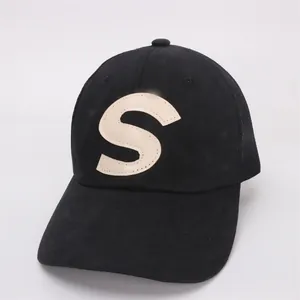 Detail of black baseball cap with mesh back and premium cream leather S patch