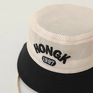 Detailed macro of kids sun hat with HONGK 1997 embroidery and breathable mesh fabric