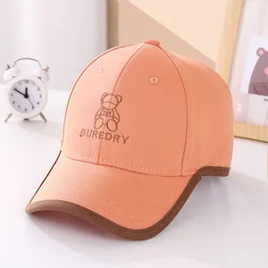 Detail of cute bear embroidery and text on orange children baseball cap