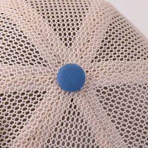 Close-up of breathable mesh texture and blue top button on the baby sun baseball cap