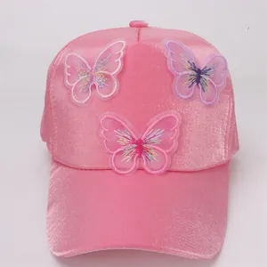 Detailed close-up of pink satin baseball cap with three 3D butterfly embroidery designs
